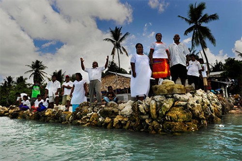 כפריים מהכפר אבאראו בקיריבאטי שמים מתפללים לישו שיציל את מדינתם מעליית פני הים  צילום: אימג'בנק 