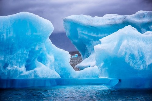 קרחוני ענק משייטים במימיה הצלולים של לגונת הקרחונים. רק קצהו של הקרחון, או כ- 10% מגודלו, בולטים מעל פני המים צילום: נמרוד גנישר 